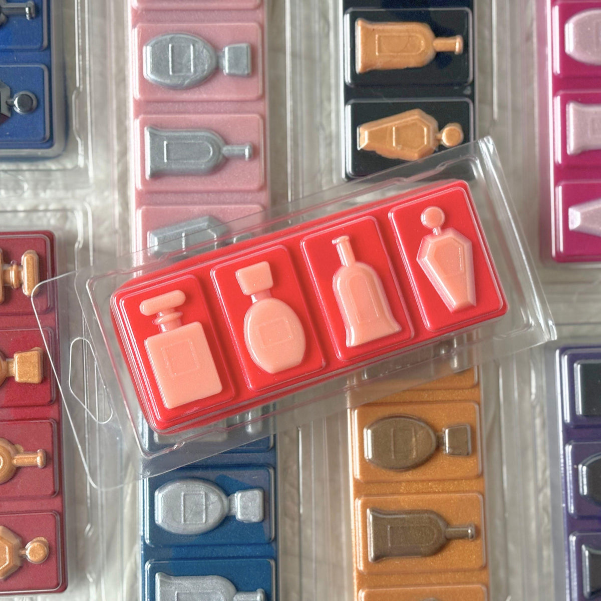 Perfume-inspired soy wax snap bars hand-poured by FAYDEN in Scotland using natural soy wax and premium fragrance oils. The image shows colourful, beautifully detailed wax melt snap bars in recyclable clear packaging, inspired by popular designer perfumes. Individual sample bars and 2oz clamshells are available, along with 3, 5 and 10-scent Discovery Boxes for exploring a selection of fragrances.