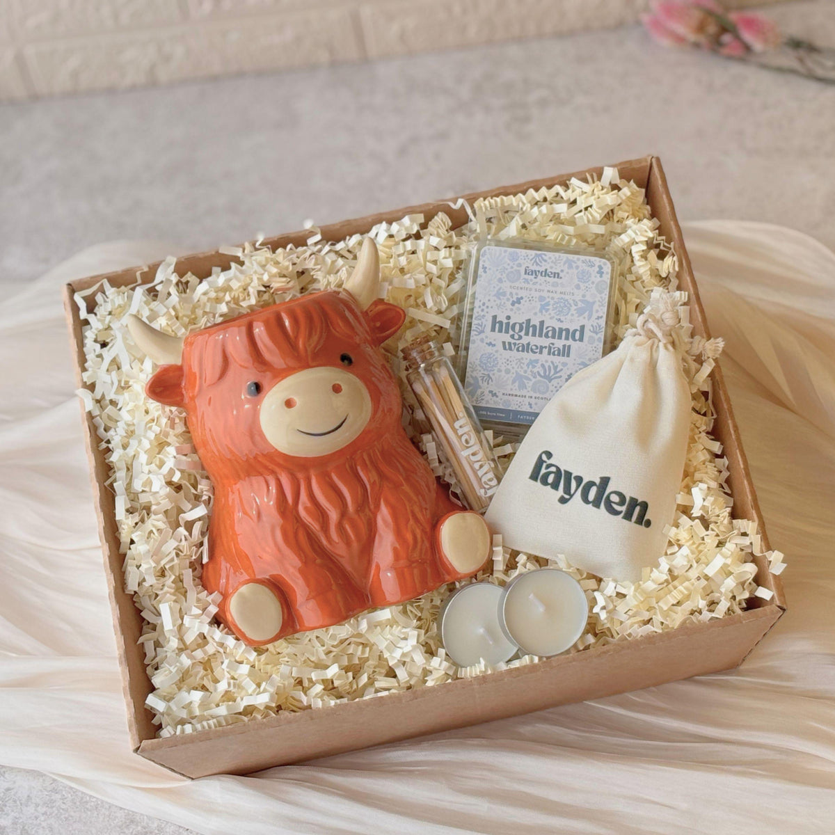 Highland cow wax melt gift set and Scottish wax burner gift, featuring a handmade soy wax melt discovery set, cosy home fragrance gift and housewarming present. A thoughtful Scottish-inspired gift for her, Highland cow lover or new home, with an 80g scented soy wax melt, ceramic wax burner, tealights and matches, beautifully gift wrapped in a kraft box with ivory ribbon. Handmade home fragrance gift for birthdays, Christmas and special occasions, ideal for cosy nights and relaxing rituals