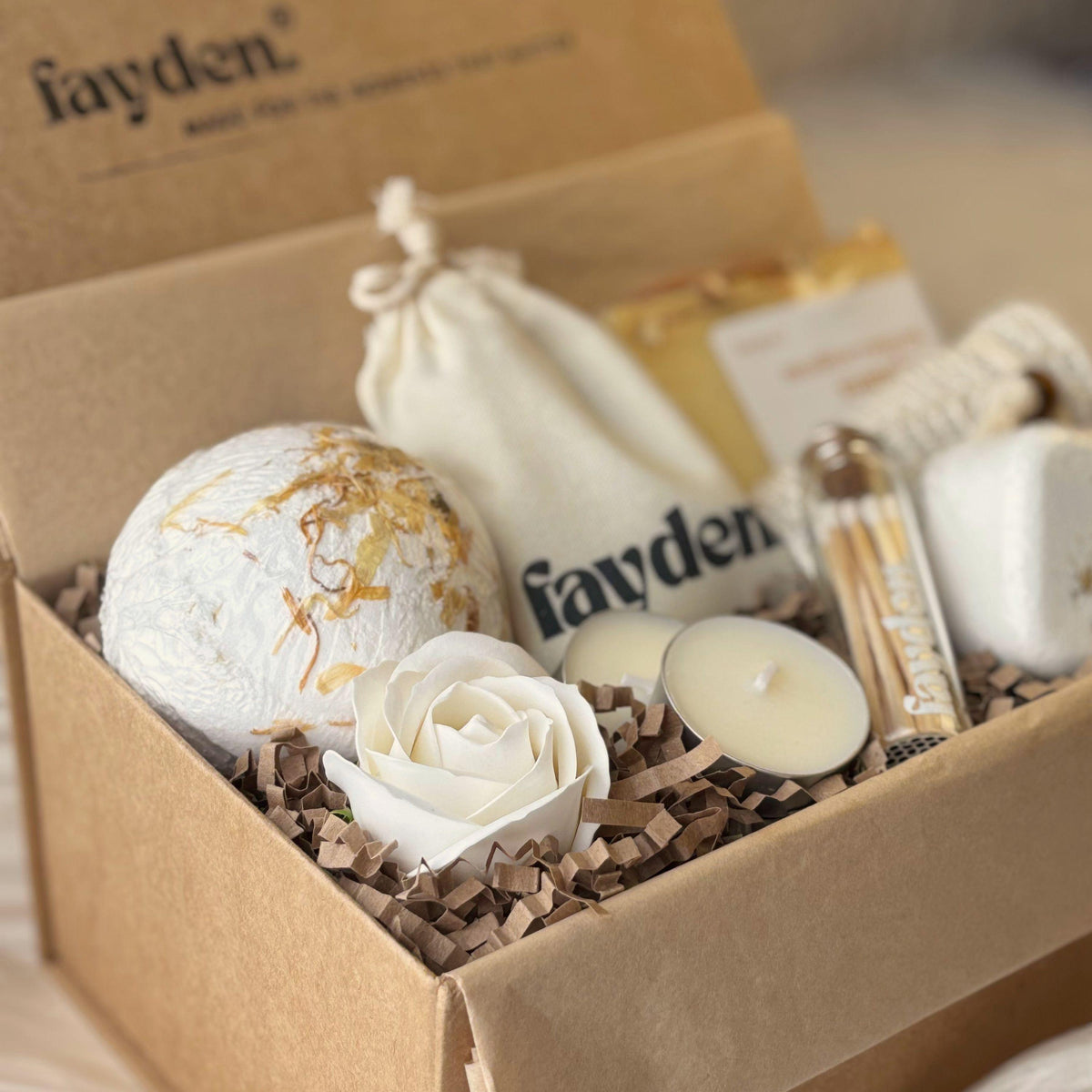 Wellness gift set with handmade soap, bath bomb and aromatherapy shower steamer, beautifully presented as a self care gift box for her. A thoughtful pamper gift, spa gift set or relaxing home fragrance gift for birthdays, Christmas, Mother's Day or a special treat. Choose the Essential or Complete wellness set, featuring FAYDEN handmade soaps, a branded pouch, tealights and matches, with a natural jute soap saver included. A lovely gift for women who enjoy slow, cosy self care rituals.