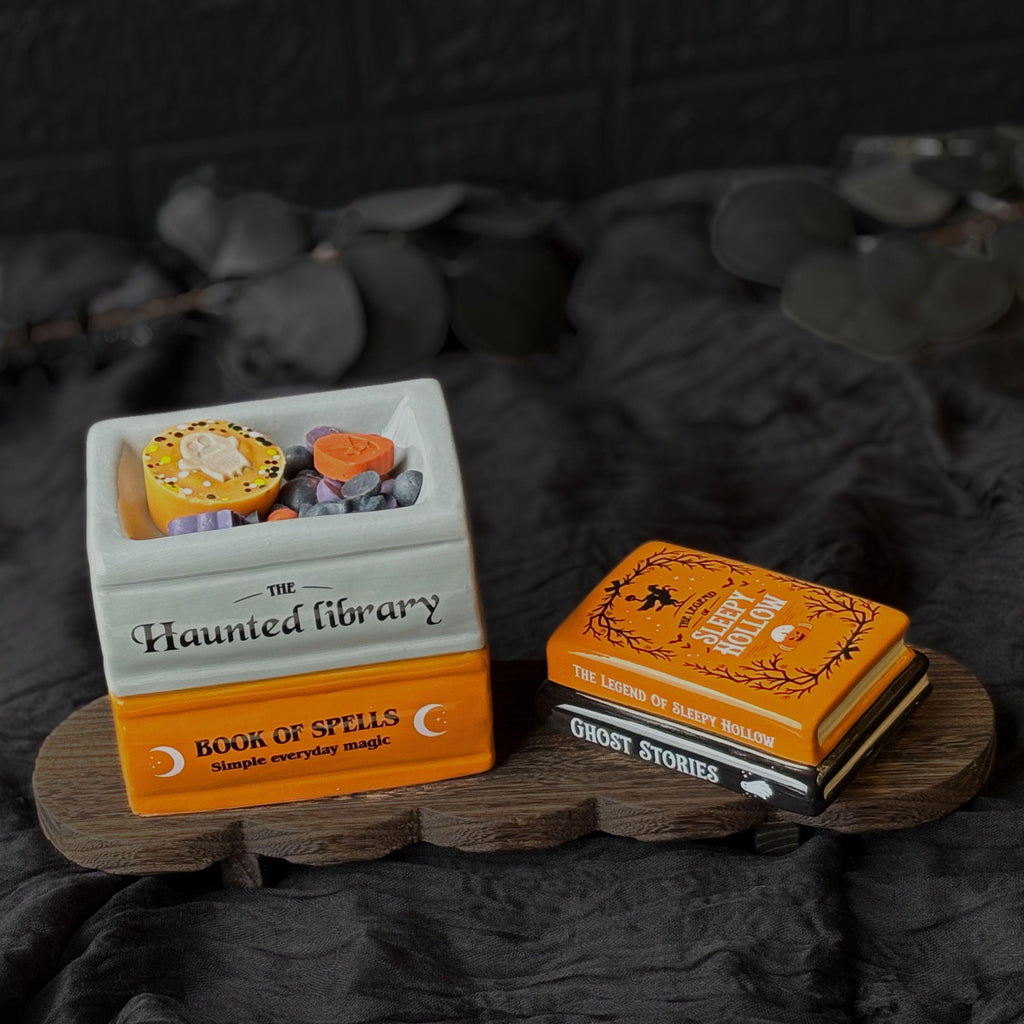 Halloween book stack wax melt burner styled with black fabric, showing a magical stack of orange, black and white book designs. A spooky ceramic oil burner for autumn home décor, cosy Halloween fragrance and wax melts.  Halloween Wax Melts
Hug In A Box Gifts
Boo Basket Gift Idea
Home Fragrance Gift
Halloween Wax Burner
Wax Melt Burners
Seasonal Oil Burners
Witchy Home Decor
Gothic Melt Burner
Ceramic Wax Burners
Pumpkin Wax Burner
Jack O Lantern
Spooky haunted House
